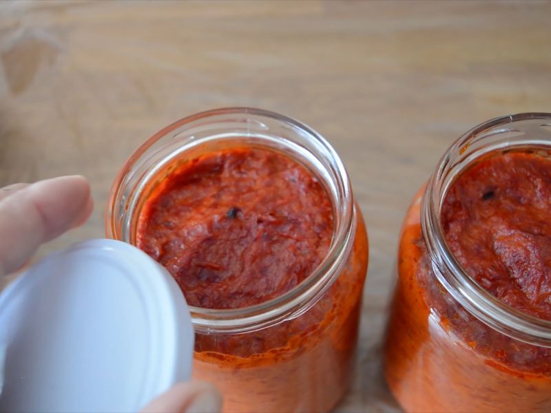 osoba zatvara teglice sa ajvarom